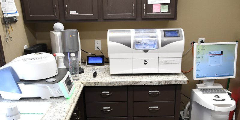 Dental laboratory workspace with various diagnostic and fabrication equipment on countertops