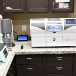 Dental laboratory workspace with various diagnostic and fabrication equipment on countertops
