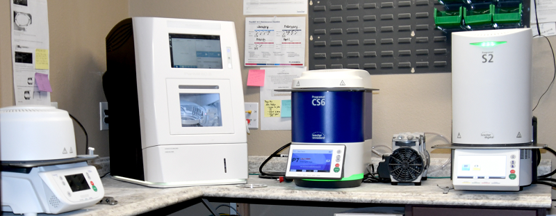 Dental laboratory station with computer, scanner, and various digital dentistry equipment